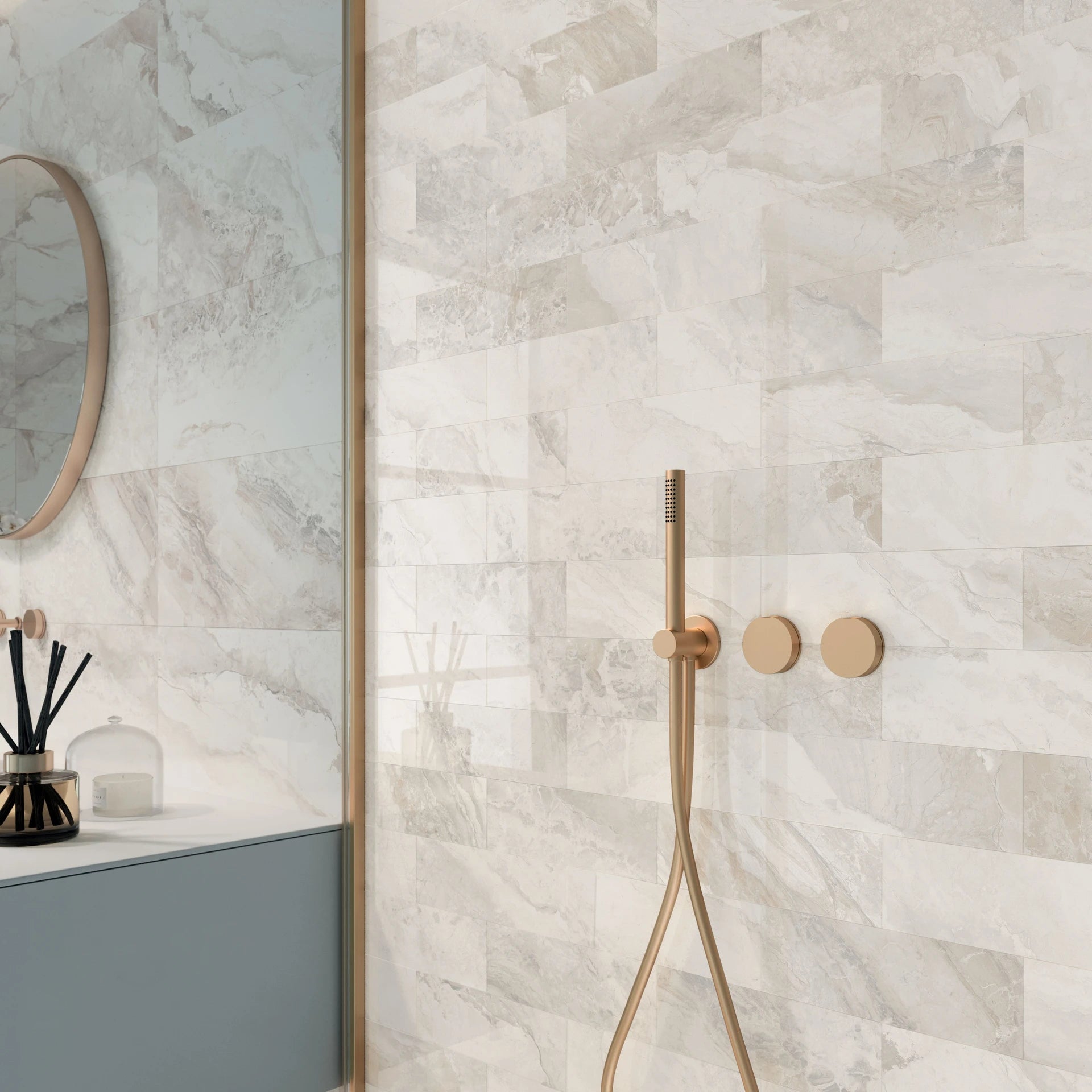 Bathroom with marble tiles, a shower head, and a mirror.