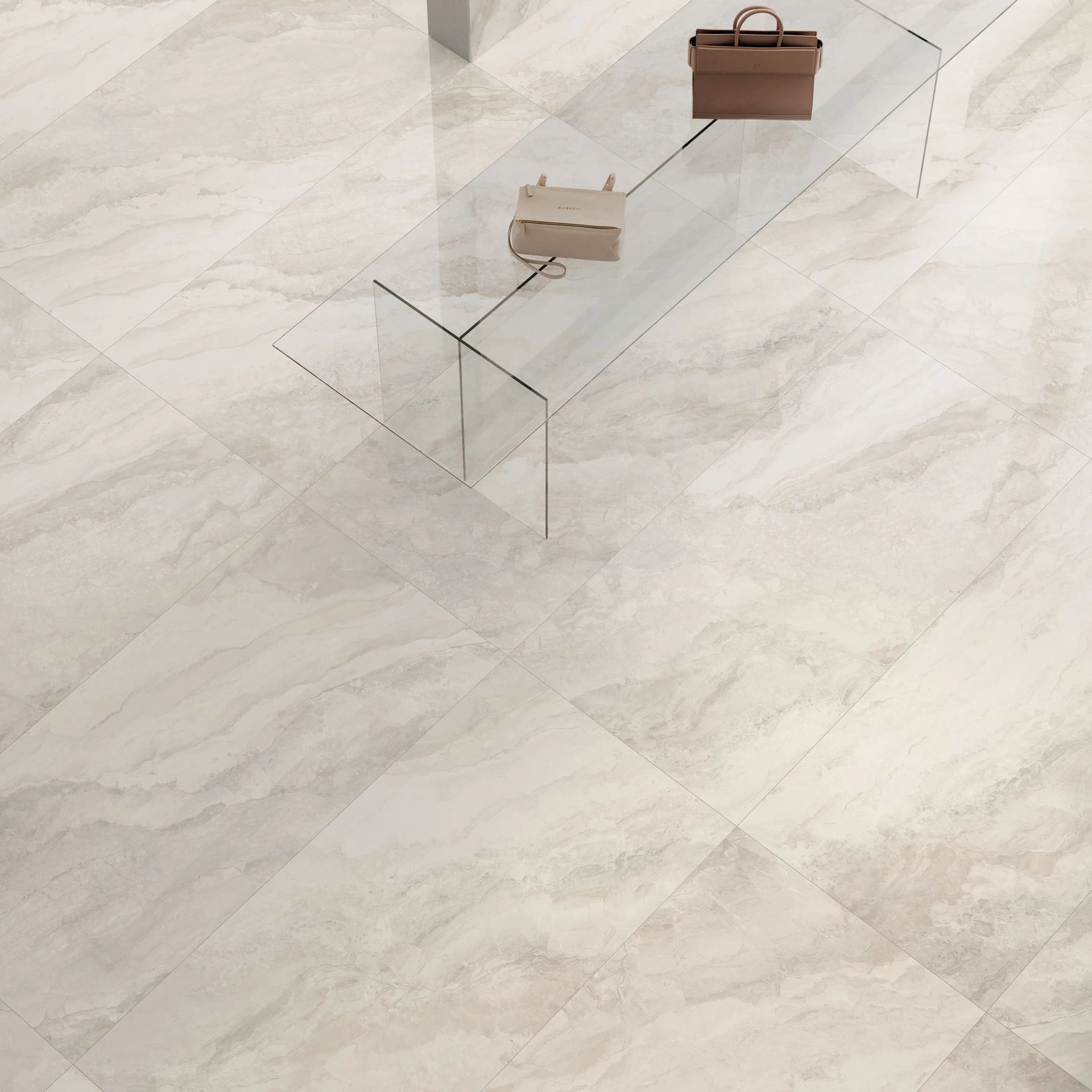 Glass coffee table with two handbags on a white marble floor